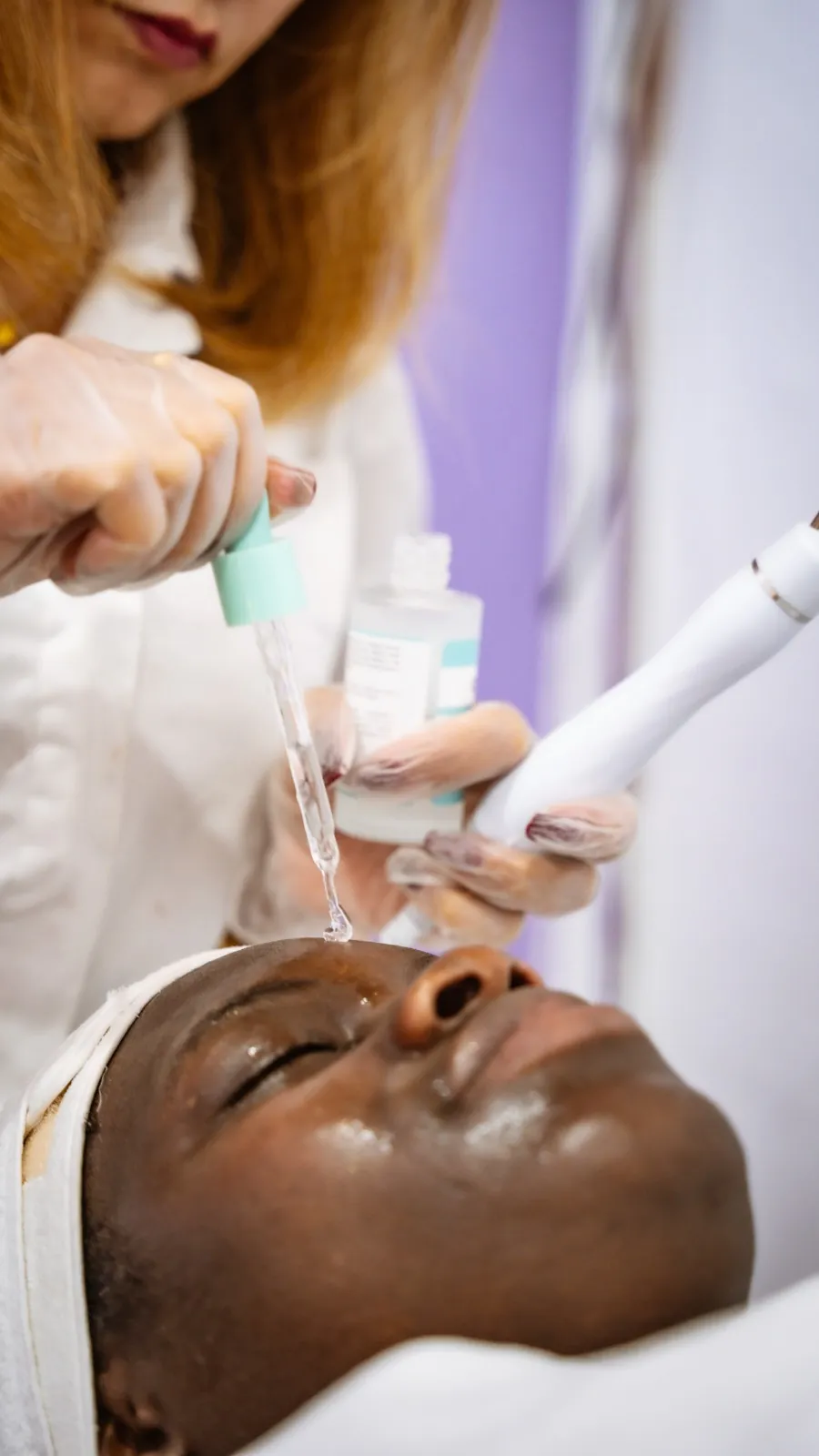 Esteticista a aplicar sérum durante uma limpeza de pele